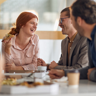 Mitarbeitende verbringen eine froehliche Pause in der Firmenkantine waehrend betrieblicher Vorsorgeangebote zur Darmkrebs-Frueherkennung.