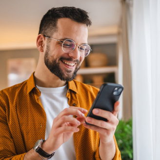 Eine Person steht im Wohnzimmer und informiert sich ueber Social Media ueber Schnelltests und Supplemente.