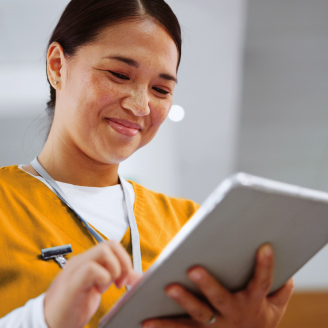 Ein Krankenpfleger laechelt auf ein Tablet, auf dem das Preventis Portal mit Patienten-Ergebnissen geoeffnet ist.