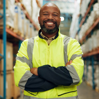 Ein Mann steht selbstbewusst im Lager fuer Vertrieb und Logistik von Diagnostik-Schnelltests.