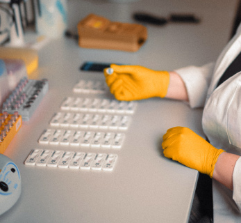 Laborfachkraft wertet mehrere Schnelltestkassetten zur Qualitaetssicherung in einem Diagnostiklabor aus.